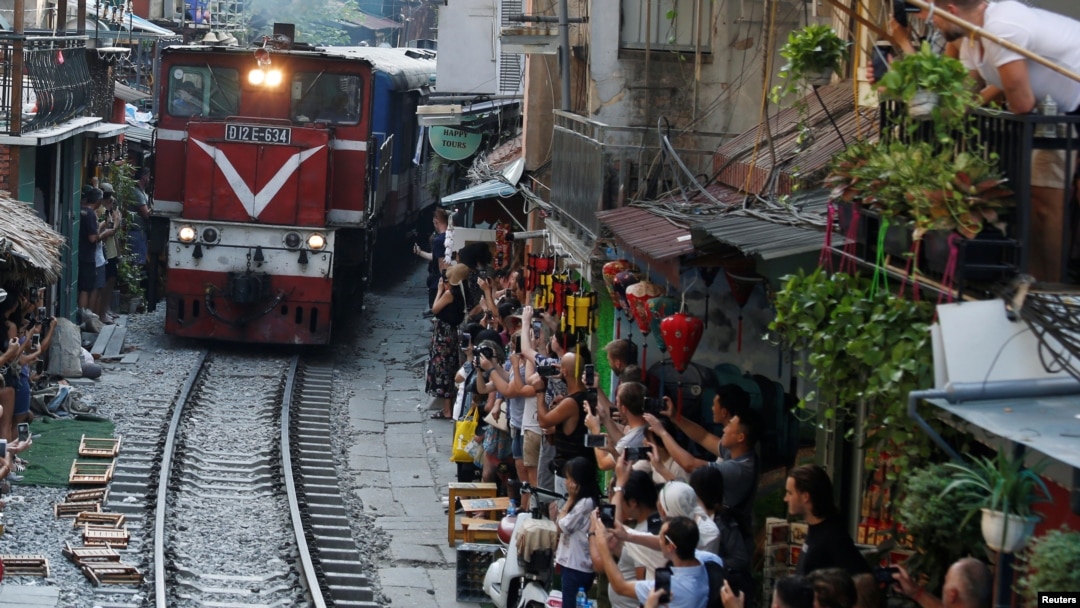Du khách chụp ảnh tàu hỏa đi qua khu phố cổ ở Hà Nội, 28/9/2019. [Ảnh minh họa]