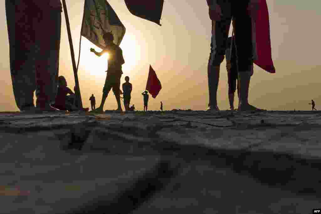 Shiite Muslim pilgrims walk in the flats near the Gulf waters as they begin their march from Iraq's southern port city of al-Faw on their way to the holy city of Karbala, ahead of the Arbaeen religious festival, on Aug. 25, 2022.