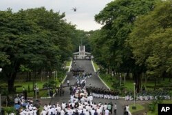 Helikopter militer menjatuhkan kelopak bunga saat pemakaman kenegaraan mendiang mantan Presiden Filipina Fidel Ramos di Makam Pahlawan di Taguig, Filipina pada Selasa 9 Agustus 2022. (AP/Aaron Favila)