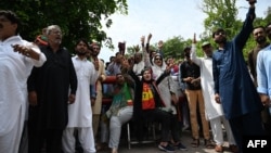Supporters of Pakistan's former prime minister Imran Khan shout slogans as they guard outside the Khan's residence in Islamabad on August 22, 2022.