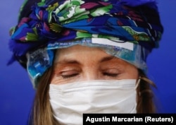 Pasien kanker Maringeles Fernandez memakai helm darurat dari kantong es yang mencegah rambut rontok, selama sesi kemoterapi, di Buenos Aires, Argentina, 10 Agustus 2022. (Foto: REUTERS/Agustin Marcarian)