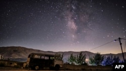 A long exposure picture taken early on Aug. 28, 2022, shows a view of the Milky Way galaxy in the sky above a derelict van in the town of Bcahrre in the mountains of Lebanon, north of the capital Beirut. 