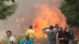Neighbors stand near a forest fire in Anon de Moncayo, Spain, Aug. 13, 2022. 