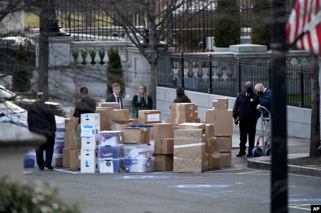 FILE - People wait for a moving van on Jan. 14, 2021, in Washington as Trump was preparing to leave the White House. (AP Photo/Gerald Herbert, File)