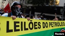 Người biểu tình cầm biểu ngữ tiến về phía trụ sở chính của Petrobras, công ty năng lượng quốc gia Brazil, tại Rio de Janeiro, ngày 21/10/2013.