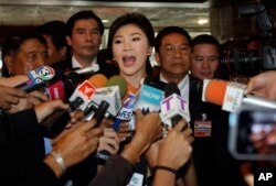 FILE - Thailand's former prime minister, Yingluck Shinawatra, talks to reporters at parliament in Bangkok, Jan. 9, 2015.