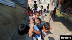 FILE - Children from the Rohingya community play outside their shacks in a camp in New Delhi, India, Oct. 4, 2018.