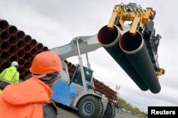 FILE - Steel pipes for the Nord Stream 2 pipeline are uploaded in Mukran harbor in Sassnitz, Germany, May 8, 2017.