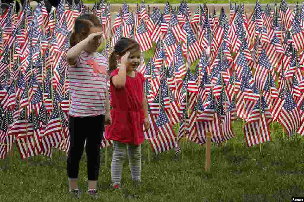 Hai bé gái giơ tay chào phía trước hàng chục ngàn quốc kỳ Mỹ tại công viên&nbsp;Boston Common ở Boston, Massachusetts.