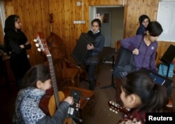 FILE - Members of the Zohra orchestra, an ensemble of 35 women, bring instruments to a class before a rehearsal at Afghanistan's National Institute of Music, in Kabul, Afghanistan, April 4, 2016.