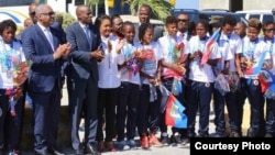 Haitian President Jovenel Moise, third from left, and Prime Minister Jacques Guy Lafontant, second from left, greet the U-20 women's team at Toussaint Louverture International Airport in Port-au-Prince with flowers, handshakes and praise for job well done, Jan. 30, 2018. (FHF photo) 