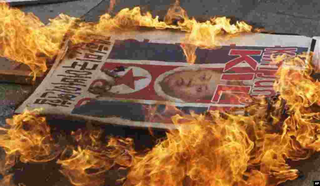 A picture of North Korean leader Kim Jong Un is burned by anti-North Korea protesters during an anti-North Korea rally denouncing North Korea's long-range rocket launch in Seoul, South Korea, Friday, April 13, 2012. (AP Photo/Lee Jin-man)
