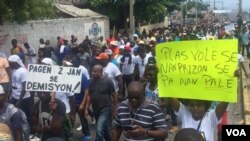 PetroCaribe anti-corruption protesters make their way around the capital, Port-au-Prince, to demand the president’s resignation. One poster reads: "There are no two ways about it, resign." The other reads: "Thieves belong in prison, not in the palace." (M. Vilme/VOA Creole)