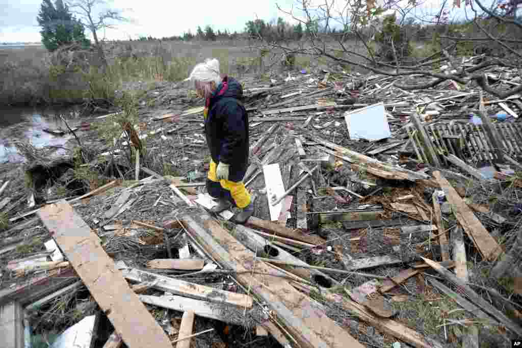 Tricia Burke walks over debris which washed up onto her property in the wake of superstorm Sandy, Nov. 1, 2012, in Brick, N.J. 