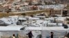 FILE - Syrian refugee children play at an informal refugee camp, which is seen set between the houses and buildings in Arsal, near the border with Syria, east Lebanon, June 13, 2018.