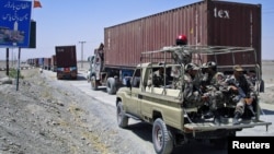 Paramilitary soldiers escort a convoy of trucks carrying supplies for NATO troops in Afghanistan, before crossing into Afghanistan from Pakistan, July 16, 2012.