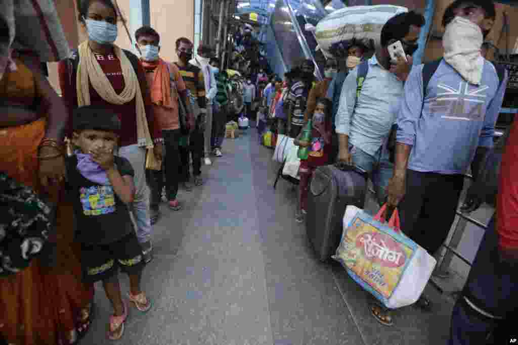 Indian passengers line up to test for COVID-19 at a health center at a railway station to test people coming from outside the city, in Ahmedabad, India.
