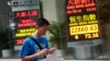 An electronic sign shows Hong Kong's benchmark Hang Seng stock index down just over 72 points by mid morning, Friday, Oct. 3, 2014.