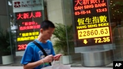 An electronic sign shows Hong Kong's benchmark Hang Seng stock index down just over 72 points by mid morning, Friday, Oct. 3, 2014.