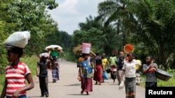 Des déplacées marchent vers le marché de Kaniki-Kapangu, près de Mwene Ditu, dans la province du Kasaï Oriental, en République démocratique du Congo, 15 mars 2018.