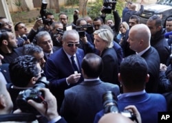 French far-right presidential candidate Marine Le Pen, center, leaves Dar al-Fatwa building, the headquarters of the Sunni Mufti, after she refused to wear a head scarf to meet with Lebanon's Grand Mufti Sheikh Abdel-Latif Derian, in Beirut, Lebanon, Feb. 21, 2017.