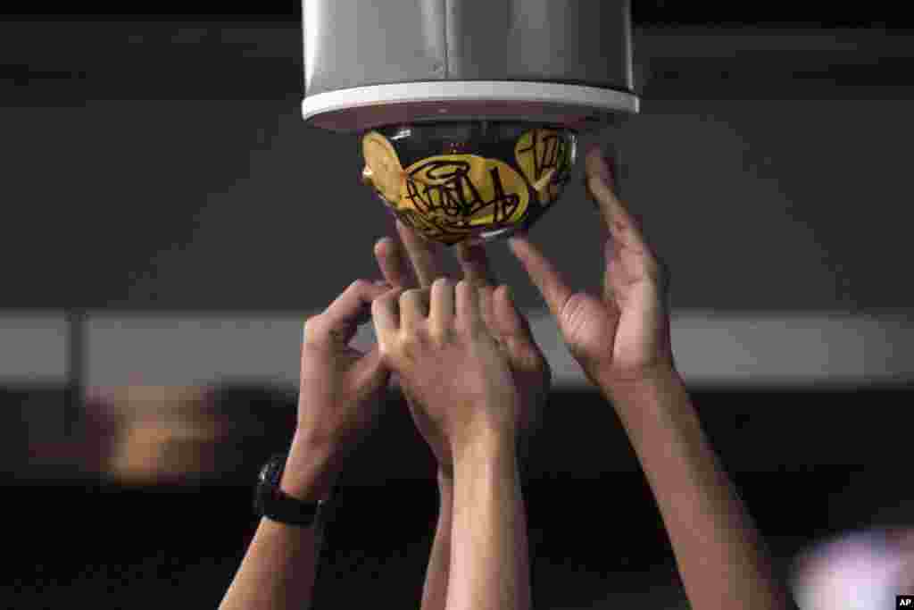 Pro-democracy protesters cover a street camera with stickers during a rally in the central business district in Bangkok, Thailand.