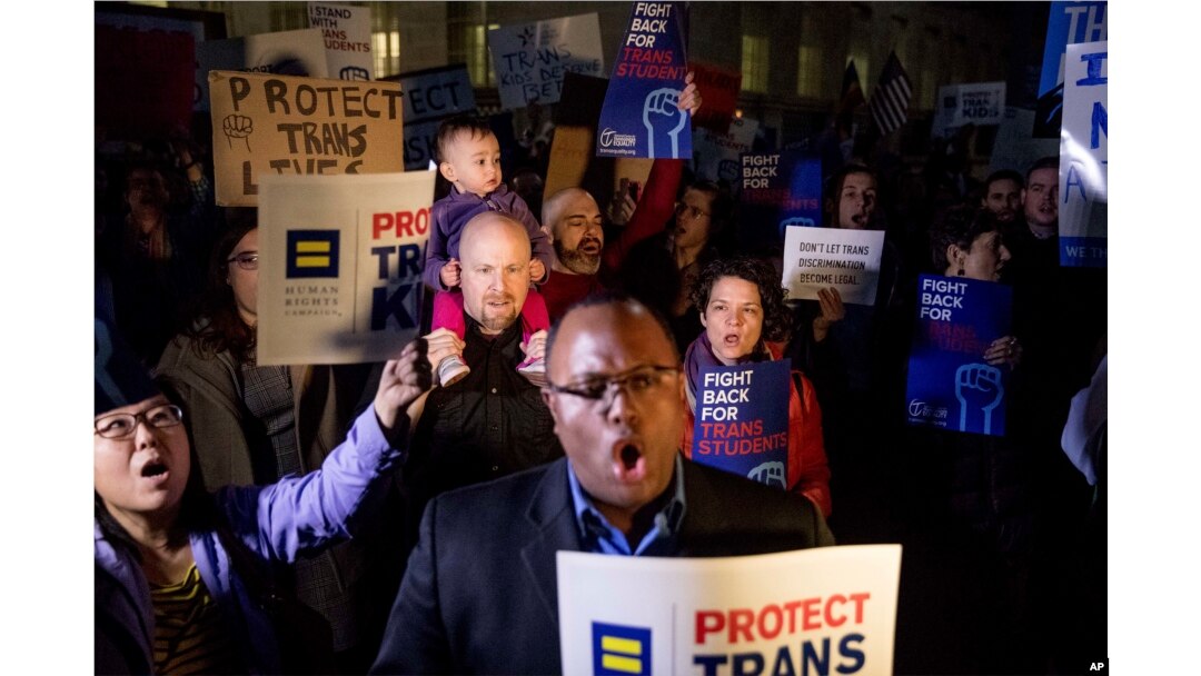 FILE - Activists and protesters with the National Center for Transgender Equality rally in front of the White House, Feb. 22, 2017, after President Donald Trump announced he would revoke some guidelines for protecting transgender student rights.