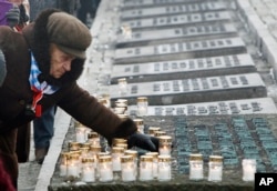 Một người sống sót sau vụ Diệt chủng thắp nến cầu nguyện cho các nạn nhân trong buổi lễ đánh dấu 69 năm giải phóng trại tử thần ở Auschwitz ở Oswiecim, Ba Lan, 27/1/2014