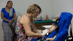 Caio Julio Vasconcelos yang lahir dengan microcephaly menjalani terapi fisik di Joao Pessoa, Brazil (25/2). (AP/Andre Penner)