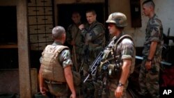 French soldiers search a house used as an armed cache in the Christian sector of PK12, the last checkpoint at the exit of the town, Bangui, Central African Republic, Feb. 11, 2014.