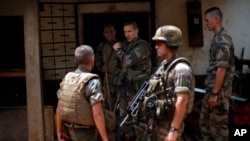 French soldiers search a house used as an armed cache in the Christian sector of PK12, the last checkpoint at the exit of the town, Bangui, Central African Republic, Feb. 11, 2014.