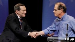 Democratic Sen. Joe Donnelly, left, shakes hands with Republican former state Rep. Mike Braun following a U.S. Senate debate in Indianapolis, Oct. 30, 2018.