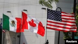 FILE - Flags of the U.S., Canada and Mexico fly next to each other in Detroit, Aug. 29, 2018. 