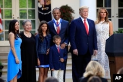 President Donald Trump, first lady Melania Trump and Tiger Woods pose for a picture with, from left, Woods' girlfriend Erica Herman, his mother Kultida Woods, children Sam Alexis Woods and Charlie Axel Woods, May 6, 2019.