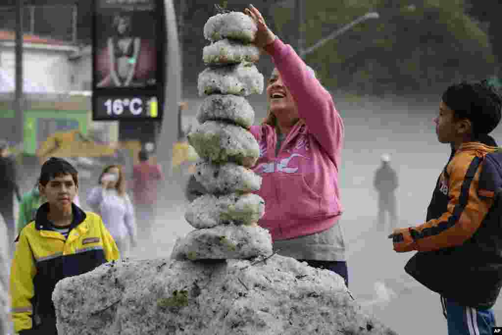 A woman makes a tower using ice from an overnight hailstorm in the Aclimacao neighborhood of Sao Paulo, Brazil.