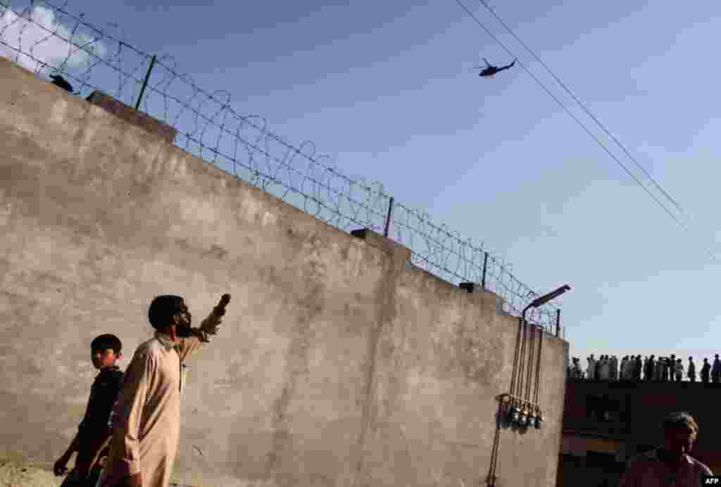 May 4: Residents look at a military helicopter flying over the compound where al Qaeda leader Osama bin Laden was killed in Abbottabad. (Reuters)