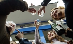 Winners of the Spanish Christmas Lottery toast with champagne at a lottery kiosk in San Sebastian, Spain.