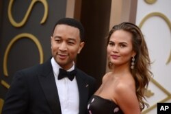 John Legend, left, and Christine Teigen arrive at the Oscars on March 2, 2014, at the Dolby Theatre in Los Angeles.