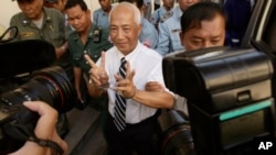 Mam Sonando, center, a local radio station owner, is escorted by court security personnel as he arrives at appeals court in Phnom Penh, Cambodia, Tuesday, March 5, 2013. Hundreds of supporters on Tuesday gathered to demand the release of Mam Sonando, one of Cambodia’s most prominent human rights defenders, who was sentenced in Oct. 2012 to 20 years in prison on insurrection charges.(AP Photo/Heng Sinith)