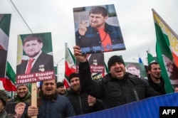 People shout slogans as they hold up images of the head of the Chechen republic Ramzan Kadyrov, during a rally in central Grozny, on January 22, 2016.