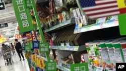 Arhiva - Žena gura kolica za kupovinu uvezena iz SAD u supermarketu u Pekingu, 2. aprila 2018.