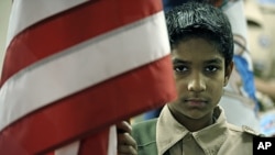 Boy Scout Omar Farooq, 12, presents the US flag for the pledge of allegiance to an audience of all faiths at the All Dulles Area Muslim Society mosque in Sterling, Virginia, March 6, 2011