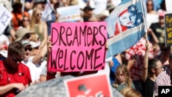 Manifestantes agitan pancartas durante un mitin de inmigración y protestas en Civic Center Park el 30 de junio de 2018, en Denver, Colorado.