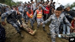 Nepalese rescue workers remove a body from the area near the wreckage of a Beechcraft 1900D operated by Buddha Air after it crashed in the mountains outside Bisankunarayan village, just south of Katmandu, Nepal, early Sunday, Sept. 25, 2011