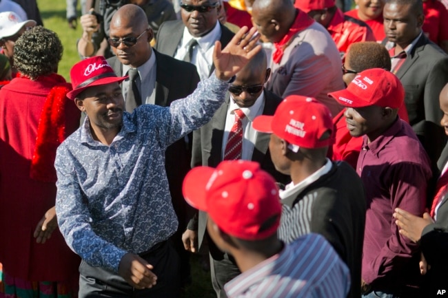 Leading opposition challenger Nelson Chamisa, left, waves at supporters as he arrives at a campaign rally in Bulawayo, Zimbabwe, July 21, 2018.