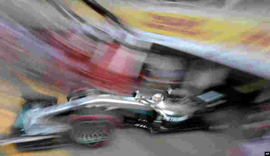 In this photo taken with slow shutter speed, Mercedes driver Lewis Hamilton of Britain starts for a Formula One training session in Hockenheim, Germany. The German Formula One Grand Prix takes place in Hockenheim on Sunday, July 31, 2016.