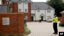 British police officers stand outside a residential property in Amesbury, England, July 4, 2018. British police have declared a "major incident" after two people were exposed to an unknown substance in the town.