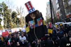 An effigy of U.S. government icon "Uncle Sam" is held up by demonstrators during a rally in front of the former U.S. Embassy in Tehran, Iran, on Sunday, Nov. 4, 2018, marking the 39th anniversary of the seizure of the embassy.