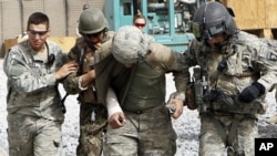 FILE - An Afghan soldier and a U.S. soldier were injured by a roadside bomb blast, Sept. 18, 2010. Such blasts can cause to traumatic brain injuries and internal bleeding. Researchers are looking at ways to better treat such injuries.