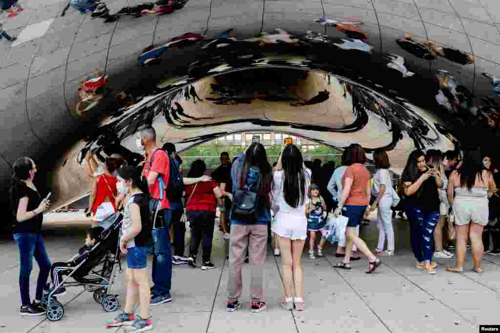 La gente disfruta de su tiempo libre durante una visita a la escultura Cloud Gate, en Millennium Park, en Chicago, Illinois, el 5 de septiembre de 2021.